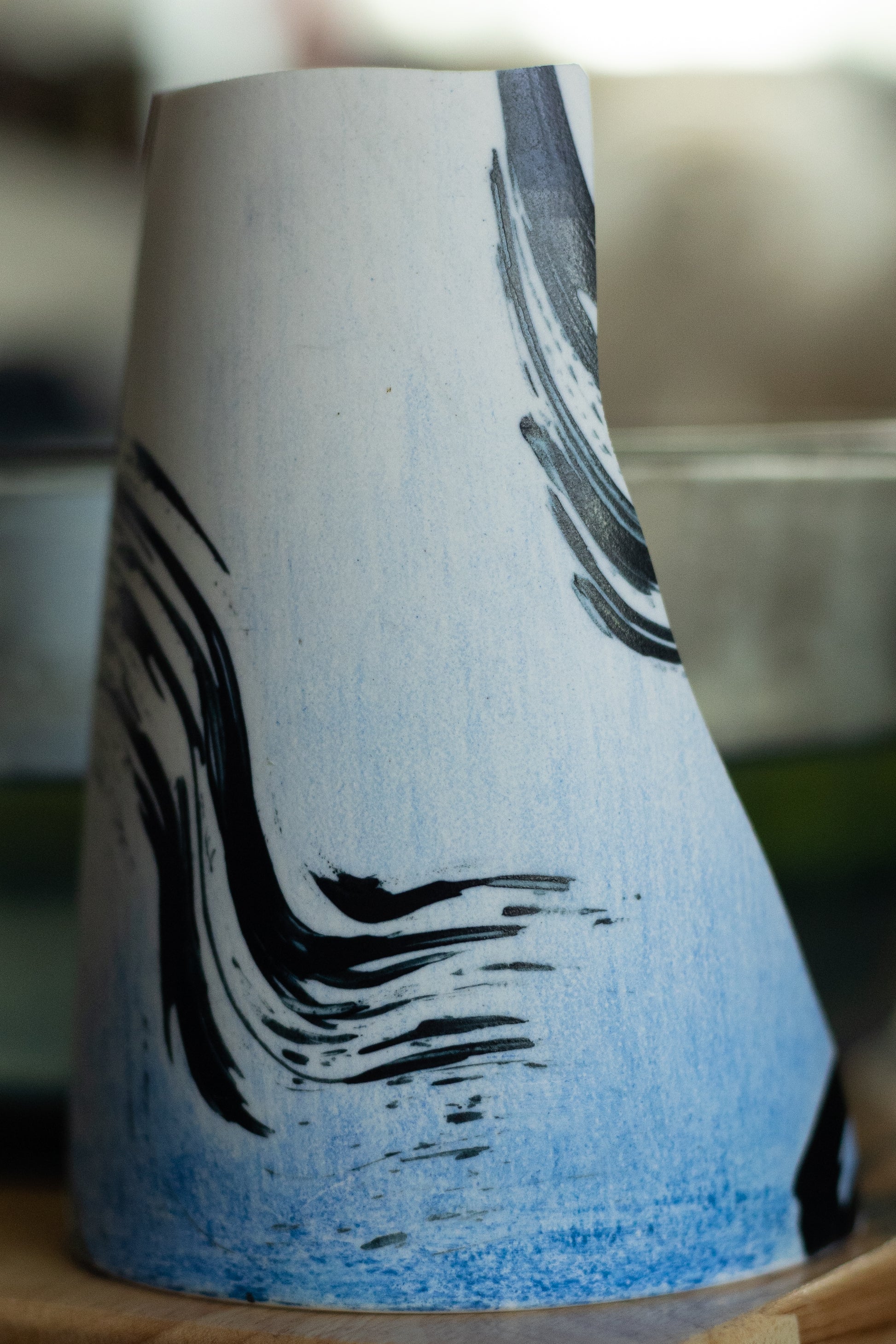 Blue pencil on fully fired porcelain, fired again to cone 06. It is permanent.